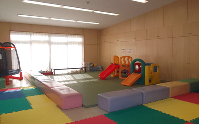 幼児用室内遊具や絵本があり床はマットレスになっている広々とした空間です